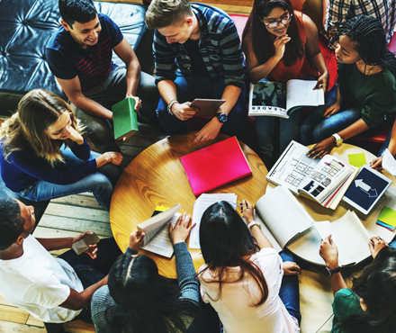 top down view of a group of students studying around a small table.