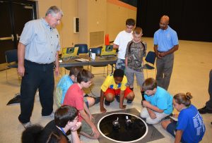 Science Camp participants test the small robots they had built and programmed in a competition. Standing at left, supervising the exercise, is VGCC Mechatronics Engineering Technology program head/instructor Keith Shearon. (VGCC photo)