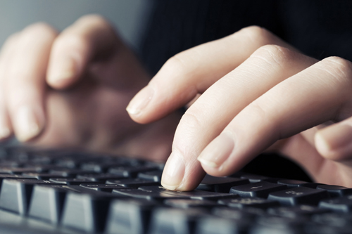 Hands typing on a keyboard