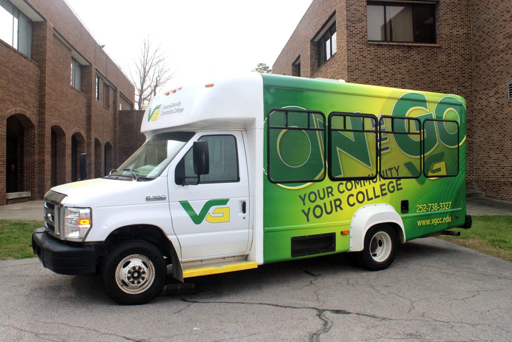 Exterior photo of Vance-Granville's On the Go Bus, which is a minibus covered in vibrant green and yellow graphics, including the Vance-Granville Community College logo